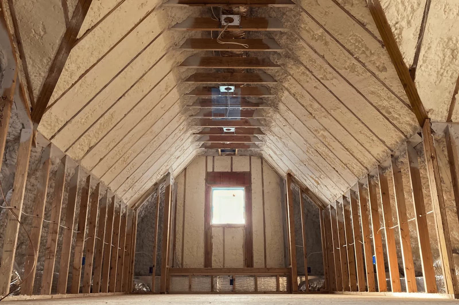 An attic with open-cell spray foam on the roof deck and gable wall