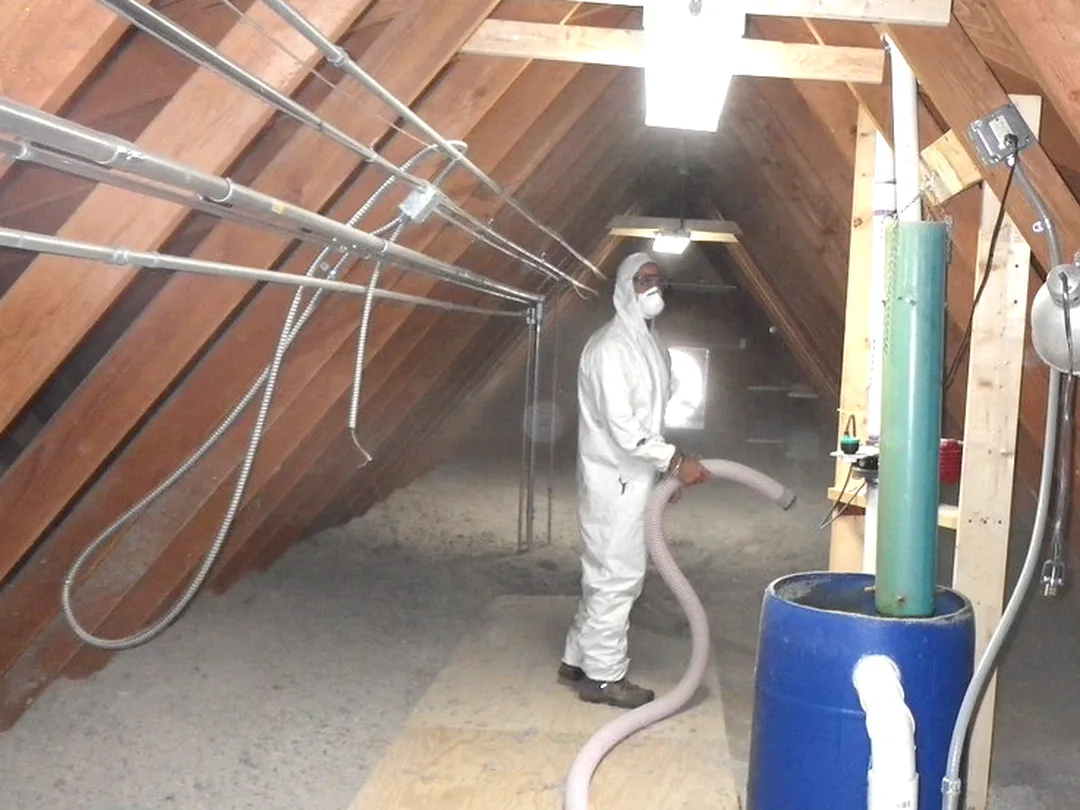 Crew blowing loose-fill insulation across an attic floor