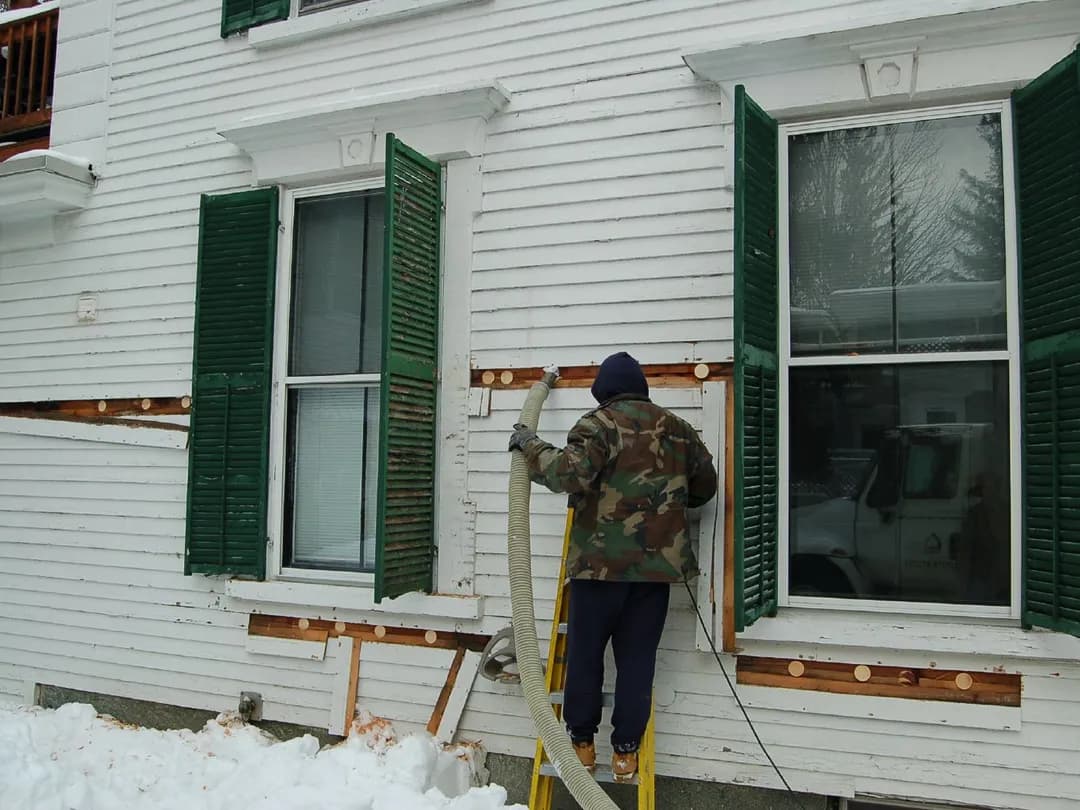 Dense-pack cellulose insulation being blown into a home's walls
