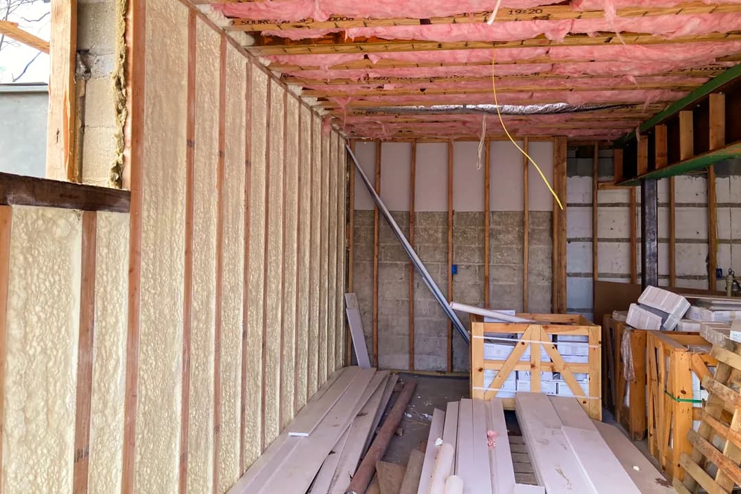Framed wall cavities sealed with closed-cell spray foam