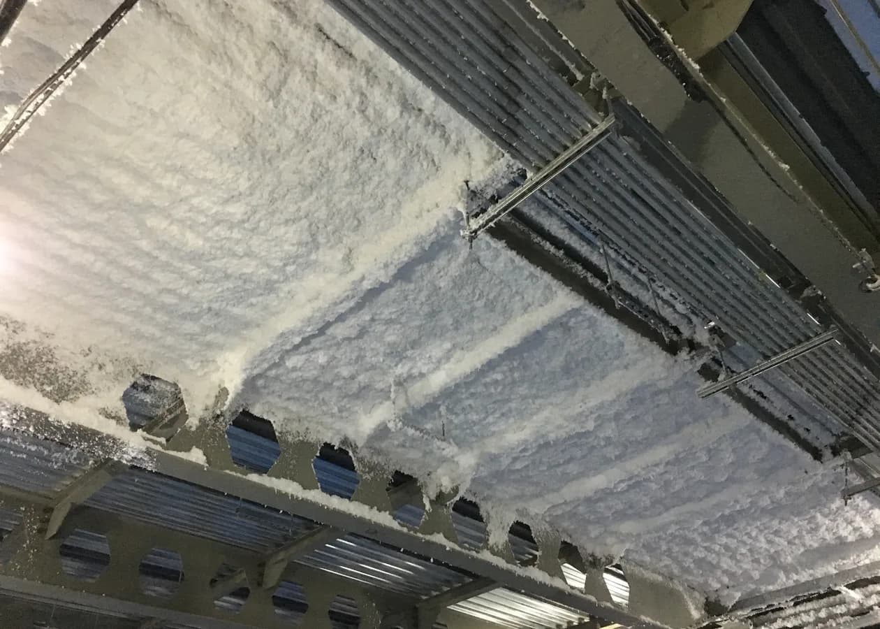 Closed-cell spray foam bonded to a corrugated metal deck between steel beams